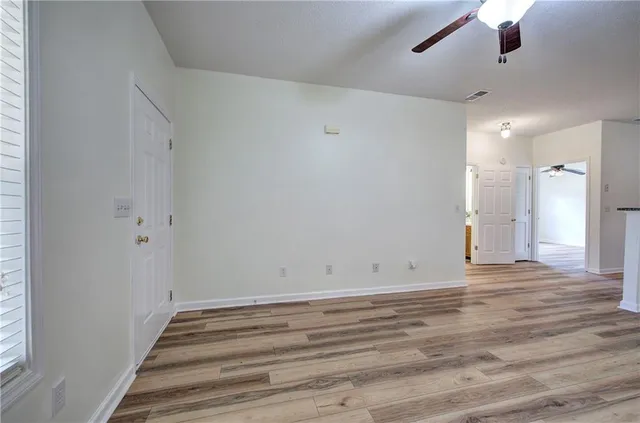 en empty room with wooden floor fan and window