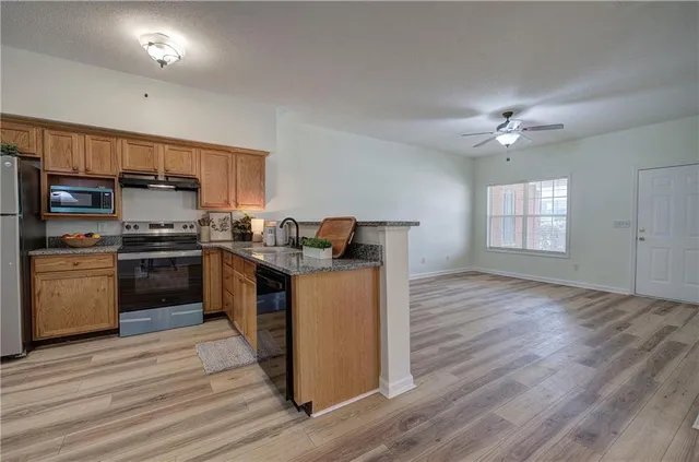 a kitchen with a refrigerator and a stove top oven