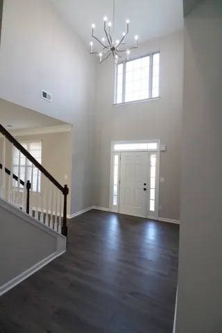 an empty room with a window and chandelier fan