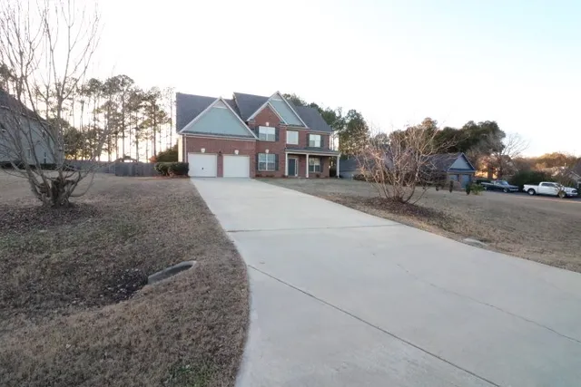 a front view of a house with a yard and trees