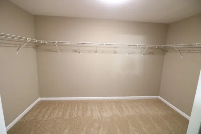 an empty room with a window and a chandelier fan