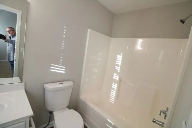 a bathroom with a sink a toilet and mirror