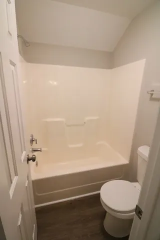 en empty room with windows and chandelier fan