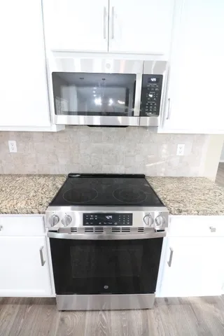 a stove top oven sitting inside of a kitchen