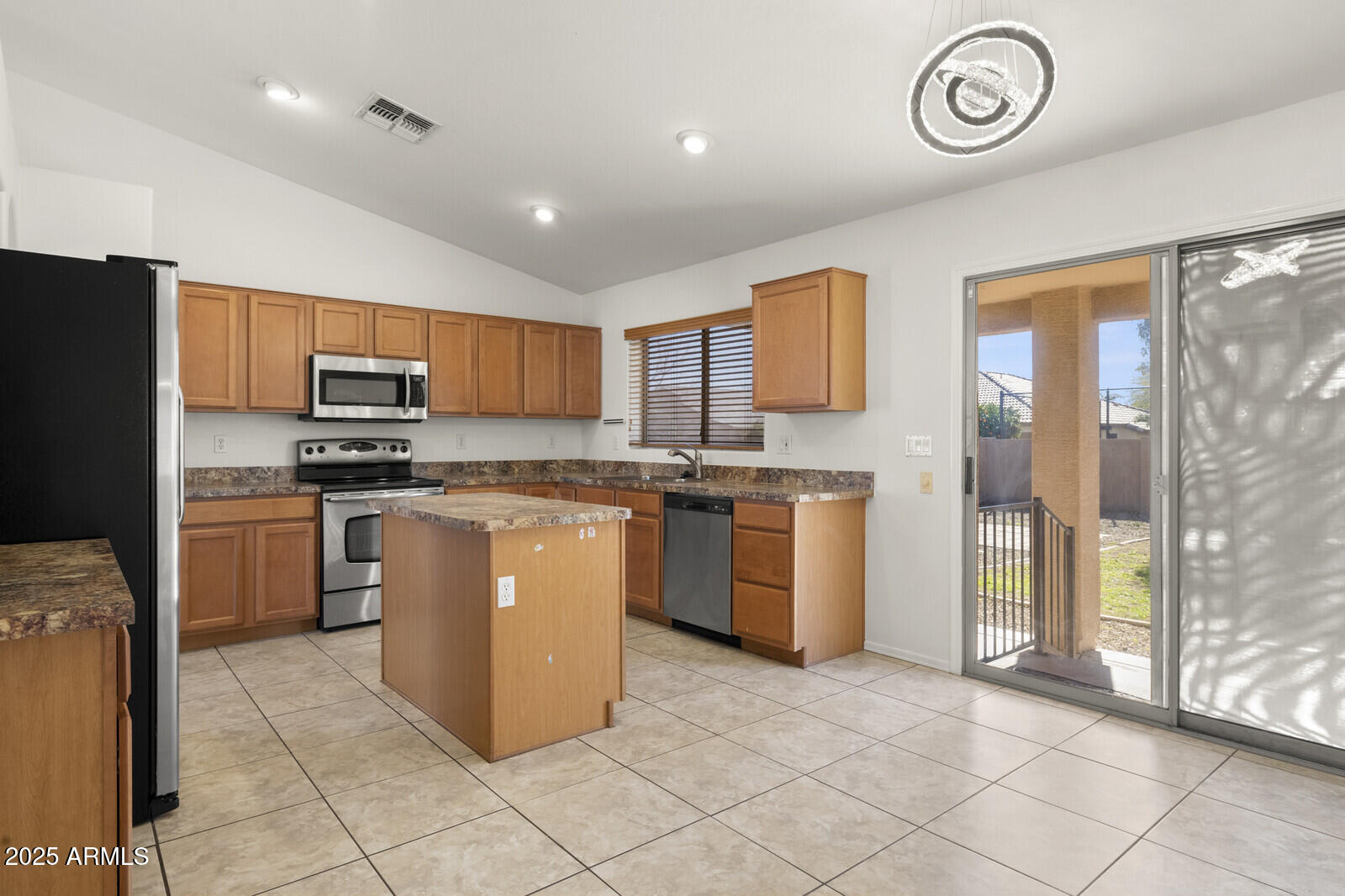 3297 East Warbler Road Gilbert, AZ 85297 - Photo 8 of 32 a kitchen with granite countertop a stove top oven a sink a counter top space and cabinets