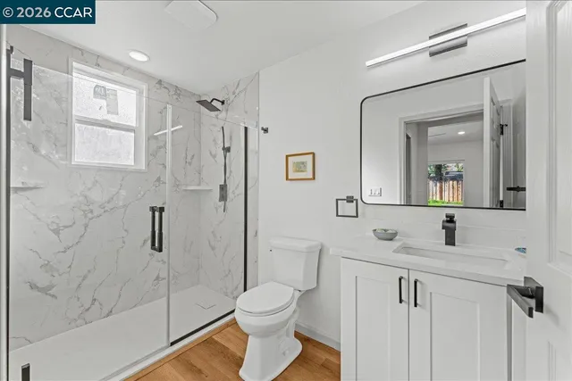 a bathroom with a granite countertop sink toilet and shower