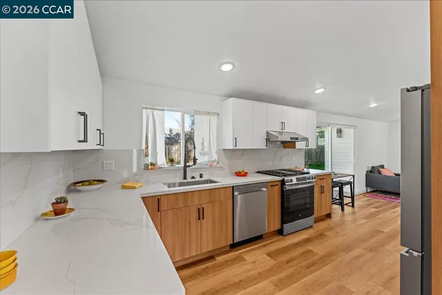 a large kitchen with stainless steel appliances lots of counter space and wooden floor
