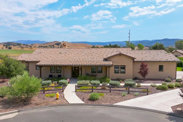 a view of a patio with couches and table and chairs with wooden fence