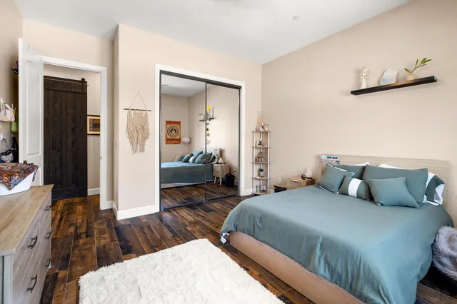 a bedroom with a bed and wooden floor