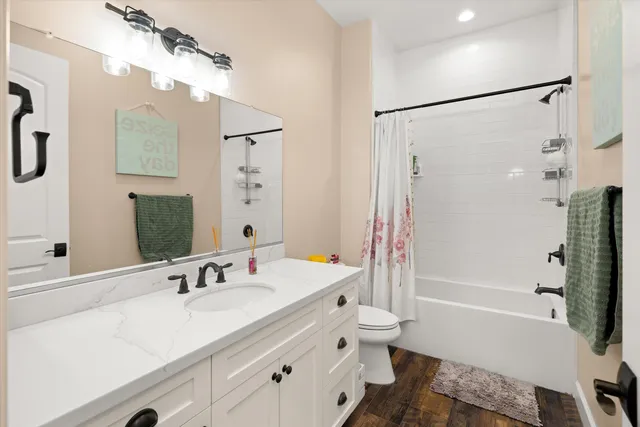 a bathroom with a tub sink toilet and a mirror