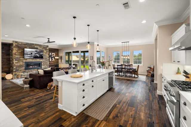 a large white kitchen with lots of counter space a sink a stove and white cabinets