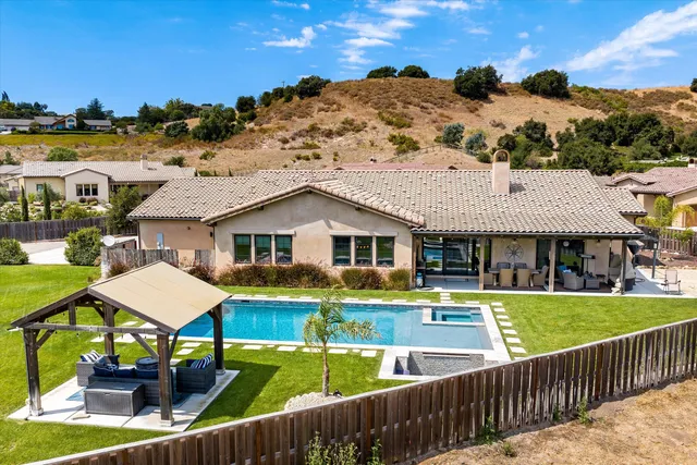 a view of a house with pool and chairs