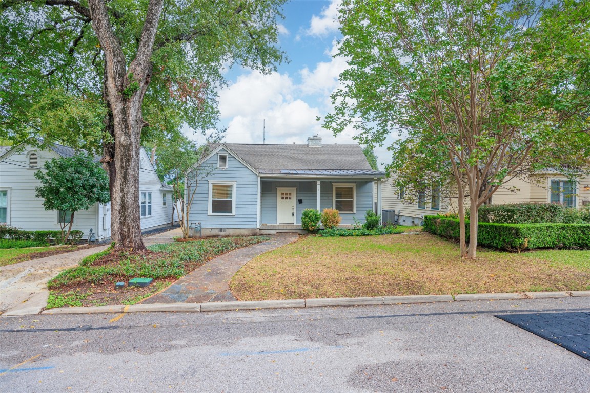 a front view of a house with a garden and trees