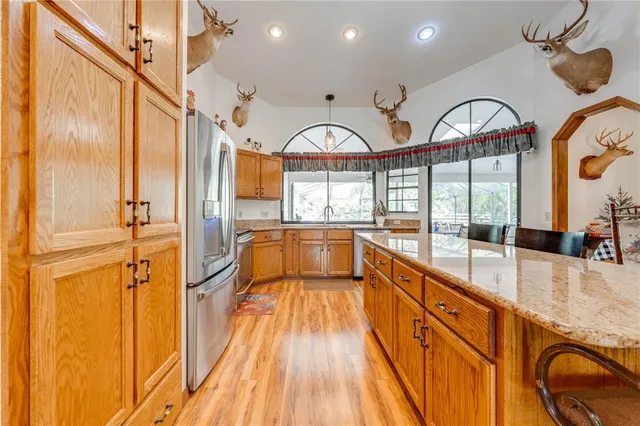 a very nice looking kitchen with a large kitchen island white cabinetry and stainless steel appliances