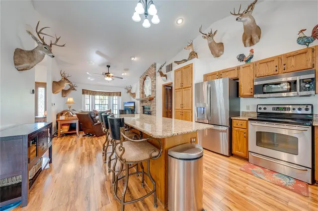 a kitchen with stainless steel appliances granite countertop a stove and wooden floors