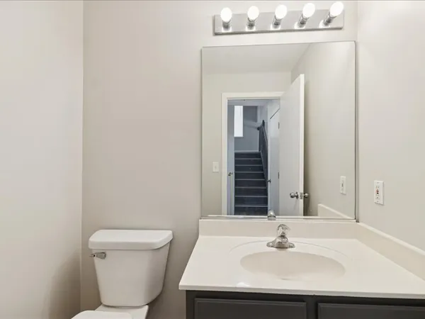 a bathroom with a sink a toilet and mirror
