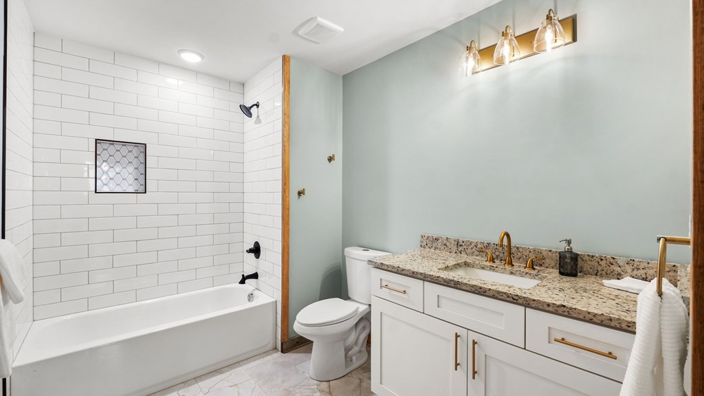 269 Old Orchard Road Ellijay, GA 30536 - Photo 11 of 17 a bathroom with a granite countertop sink a toilet a mirror a bathtub and shower