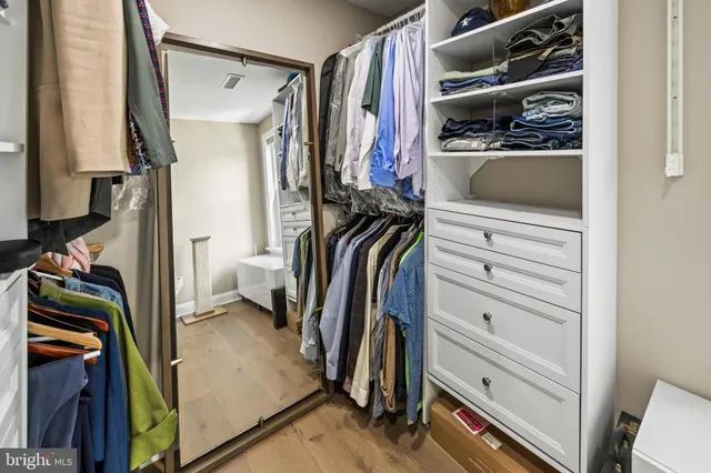a view of walk in closet with clothes and shoes