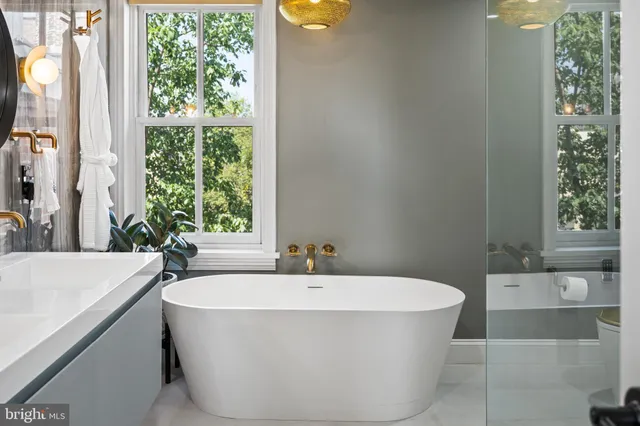 a white bath tub sitting in a bathroom next to a window
