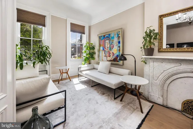 a living room with furniture a potted plant and a large window