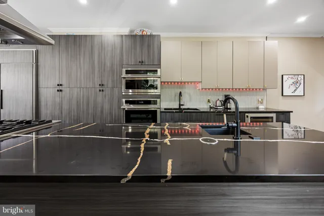 a living room with kitchen appliances a sink and a stove