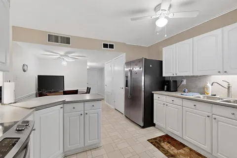 a kitchen with cabinets stainless steel appliances and a window