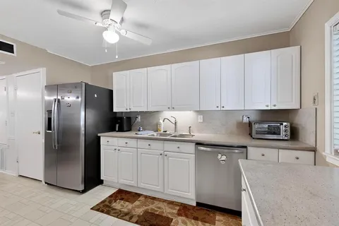 a kitchen with stainless steel appliances granite countertop a stove a refrigerator and a sink with cabinets
