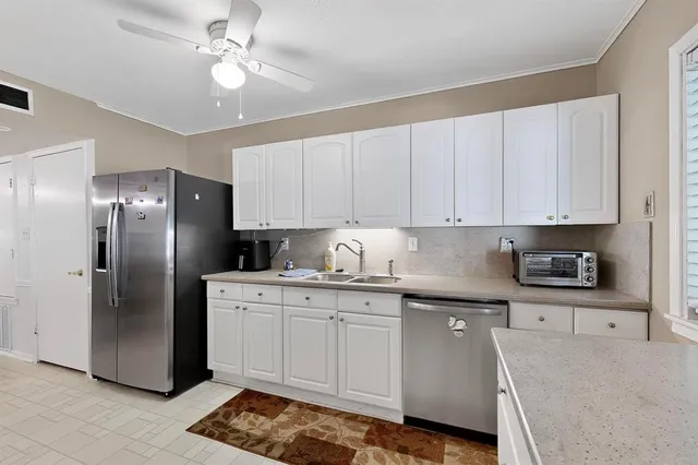 a kitchen with stainless steel appliances granite countertop a stove a refrigerator and a sink with cabinets