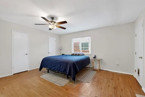 a spacious bedroom with a bed and a ceiling fan