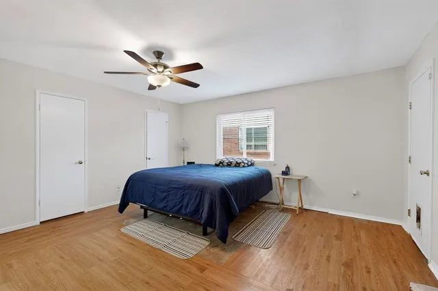 a spacious bedroom with a bed and a ceiling fan