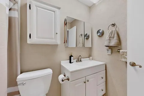 a bathroom with a toilet sink and mirror