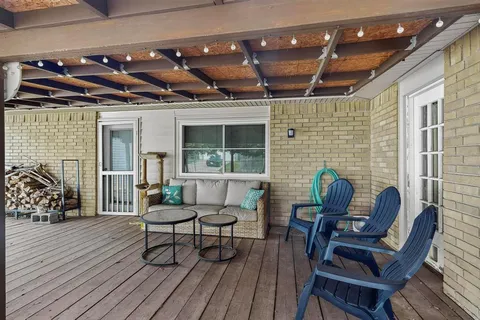 a view of a patio with table and chairs with wooden floor and fence