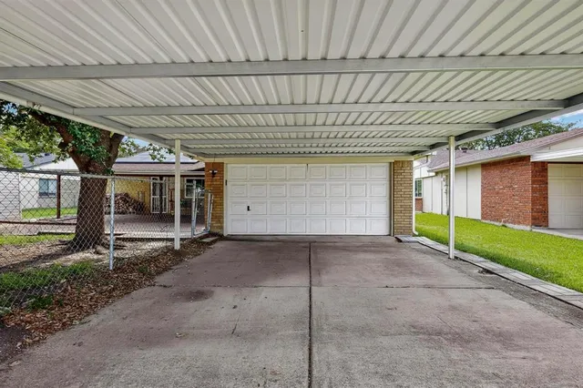 a view of a house with backyard and parking area