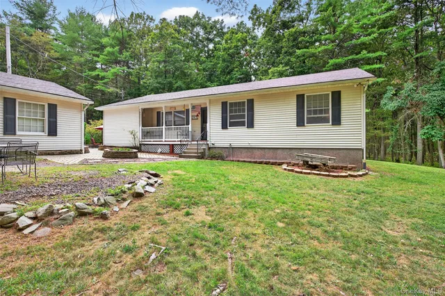 a view of a house with backyard and sitting area