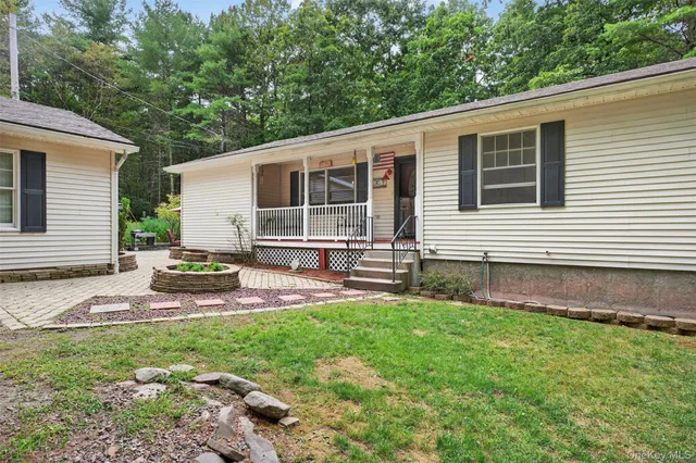 a view of house with backyard and sitting area