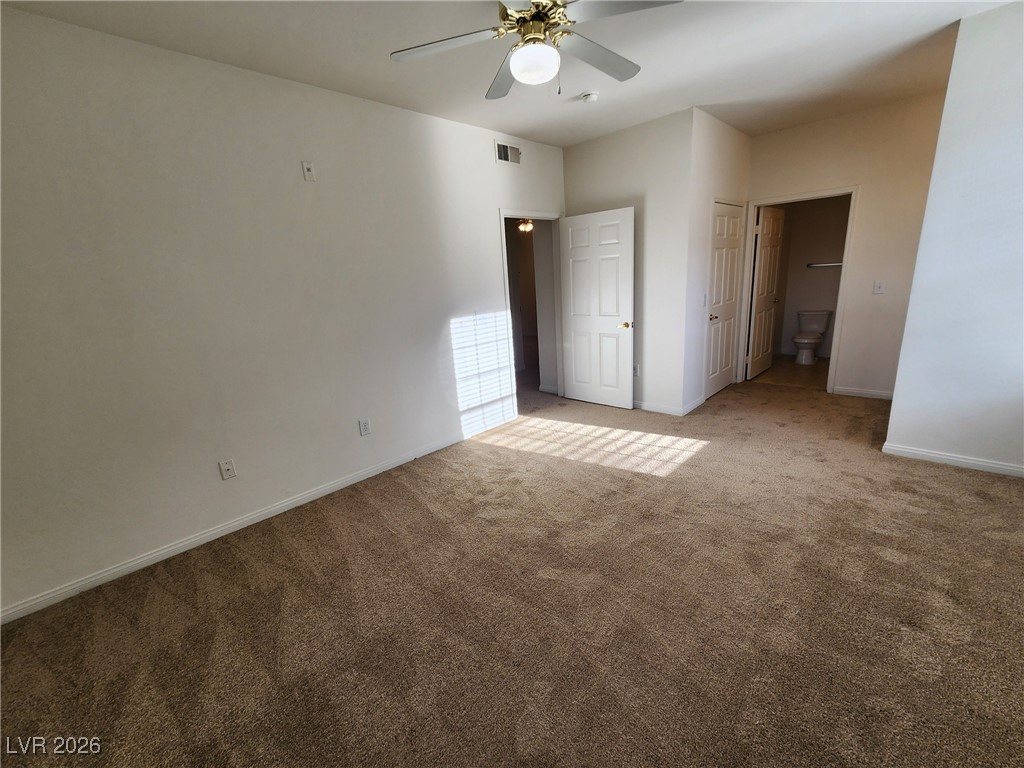 231 West Horizon Ridge Parkway, Unit 417 Henderson, NV 89012 - Photo 31 of 45 Unfurnished bedroom with carpet floors, a ceiling fan, and ensuite bathroom