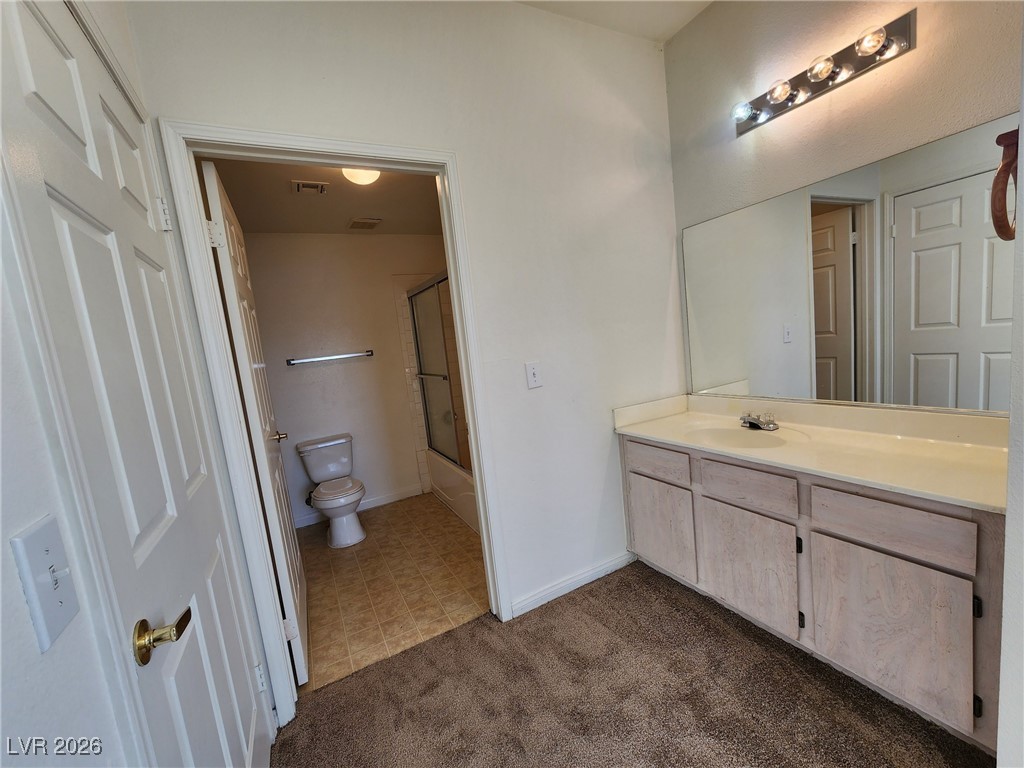 231 West Horizon Ridge Parkway, Unit 417 Henderson, NV 89012 - Photo 33 of 45 Bathroom featuring vanity, dark carpet, and bath / shower combo with glass door
