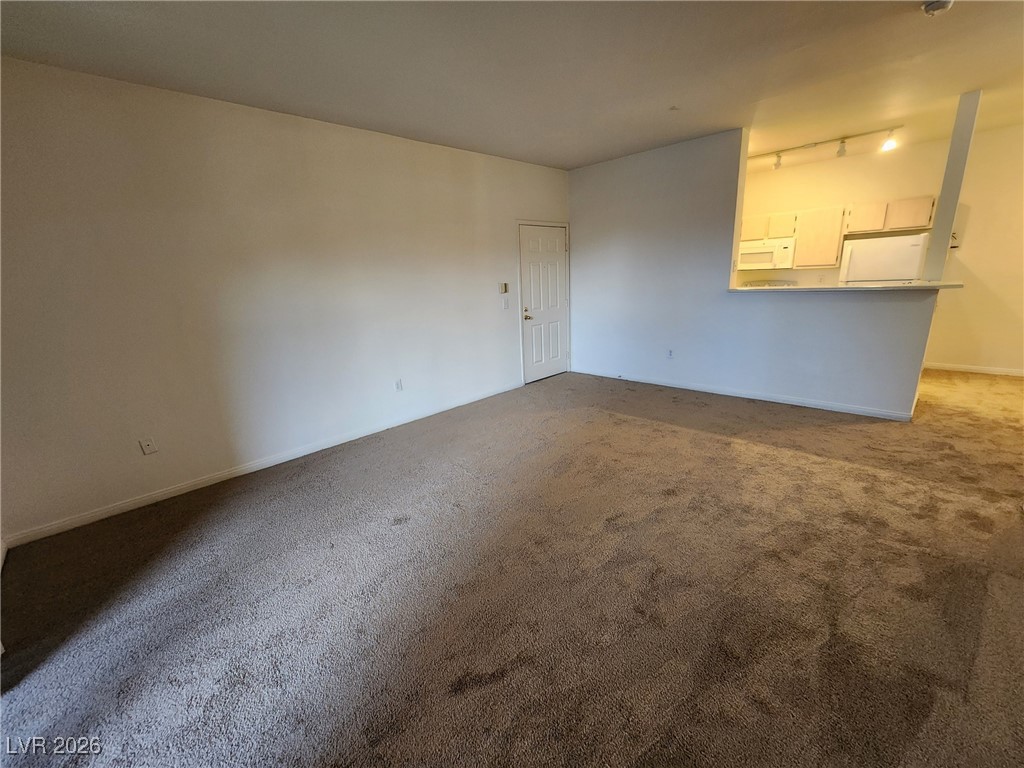 231 West Horizon Ridge Parkway, Unit 417 Henderson, NV 89012 - Photo 5 of 45 Empty room featuring dark colored carpet and track lighting