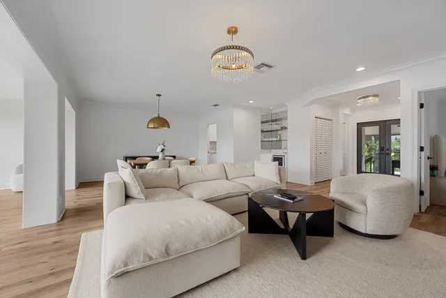 a living room with furniture and a chandelier