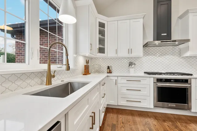 a kitchen with granite countertop a sink stainless steel appliances and cabinets