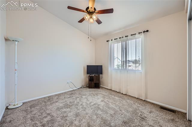 12510 Motley Road Peyton, CO 80831 - Photo 24 of 36 Unfurnished room with carpet flooring, lofted ceiling, and ceiling fan