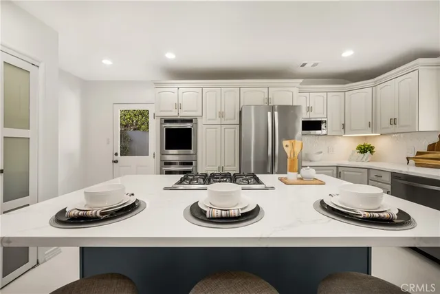 a kitchen with sink refrigerator dining table and chairs
