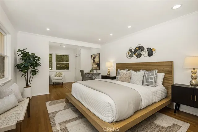 a bedroom with a large bed and a potted plant