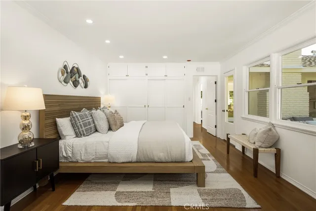 a bedroom with a bed and wooden floor