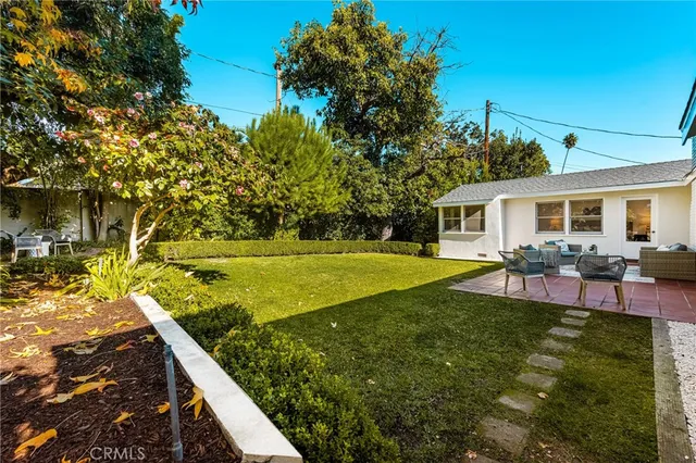 a view of a house with backyard and sitting area