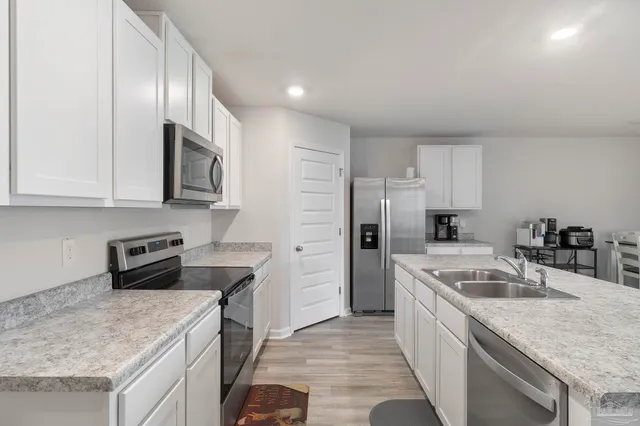 a kitchen with a sink dishwasher a stove and a refrigerator with wooden cabinets