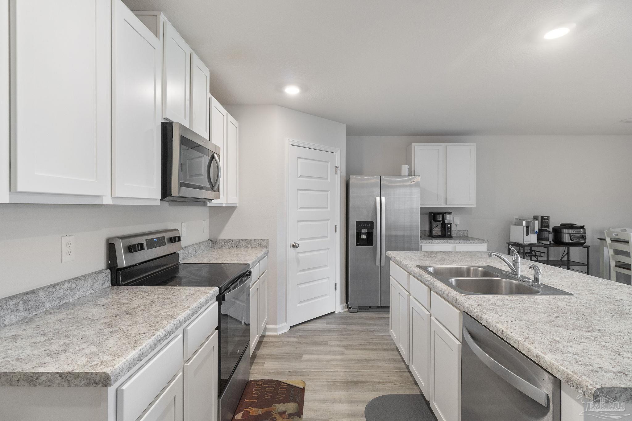 4358 Redbay Court Pace, FL 32571 - Photo 13 of 47 a kitchen with a sink dishwasher a stove and a refrigerator with wooden cabinets