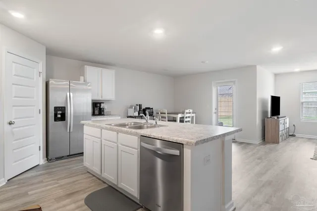 a kitchen with a sink a refrigerator and cabinets