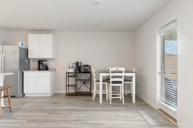 a view of a kitchen with wooden floor and electronic appliances