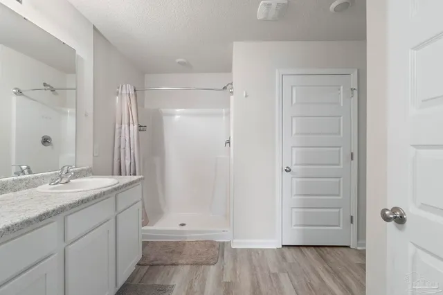a bathroom with a granite countertop sink shower and mirror